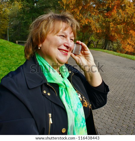 Happy middle aged woman talking on a cell phone