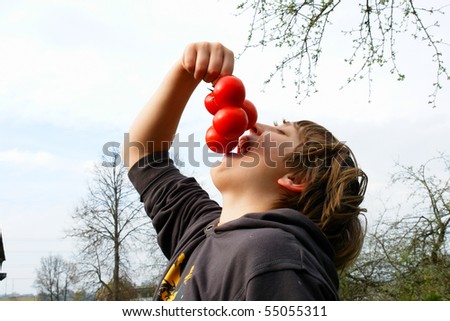 The boy wants to try the tasty tomato