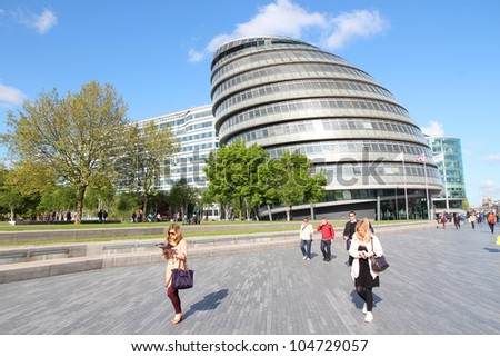 LONDON - MAY 16: Tourists walk next to the City Hall (GLA) on May 16, 2012 in London. With more than 14 million international arrivals in 2009, London is the most visited city in world (Euromonitor).