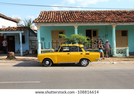 VINALES, CUBA - JANUARY 31: People walk past Russian car on January 31, 2011 in Vinales, Cuba. 2012 change in law allows Cubans to trade cars again. Cars in Cuba are very old because of the old law.