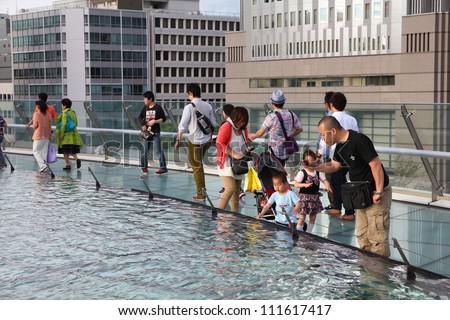 NAGOYA, JAPAN - MAY 3: Tourists visit Oasis 21 architecture complex on May 3, 2012 in Nagoya, Japan. Oasis 21 has won multiple awards, including IESNA Award of Distinction.