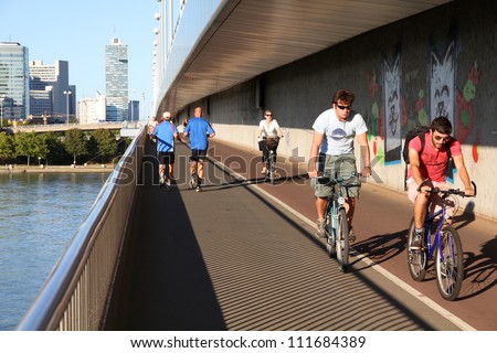 VIENNA - SEPTEMBER 6: Pedestrians walk and cyclists ride on September 6, 2011 in Danube river bridge, Vienna. Vienna is often quoted among most bicycle and pedestrian friendly cities.