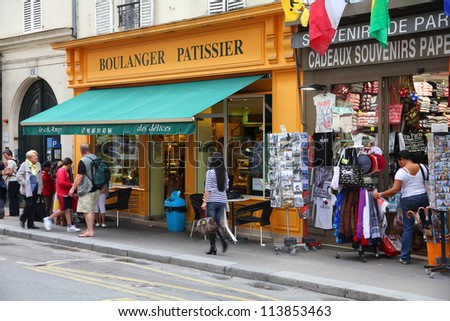 PARIS - JULY 21: Tourists walk past a souvenir store on July 21, 2011 in Paris, France. Paris is the most visited city in the world with 15.6 million international arrivals in 2011.