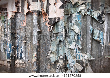Torn posters on old metal wall - vandalism and urban decay in Spain
