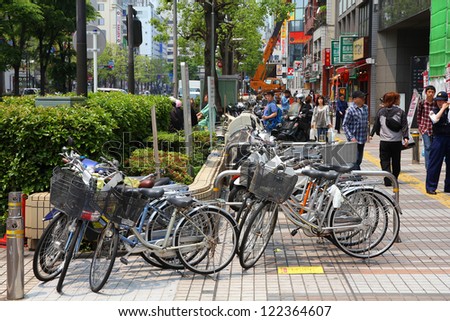 KAWASAKI, JAPAN - MAY 10: People walk by parked bicycles on May 10, 2012 in Kawasaki, Japan. Cycling is one of most popular transport modes in Kawasaki, city inhabited by 1.44 million people.
