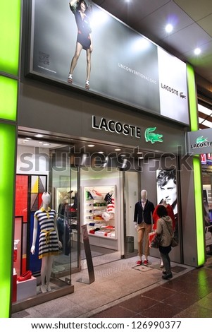 KOBE, JAPAN - APRIL 23: Customer enters Lacoste store on April 23, 2012 in Kobe, Japan. Lacoste is present in 112 countries. It exists since 1933 and has 1,000 stores.