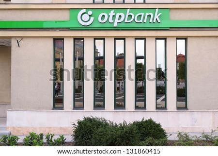 KESZTHELY, HUNGARY - AUGUST 11: People reflect in OTP Bank branch on August 11, 2012 in Keszthely, Hungary. OTP is the biggest commercial Hungarian bank with 1500 branches in 9 countries.
