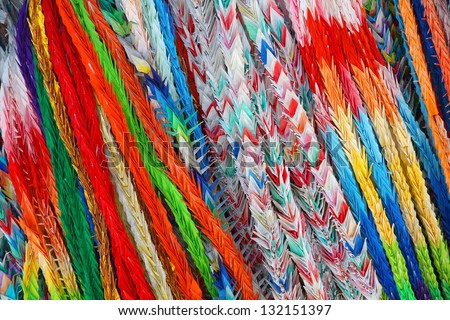 Hundreds of origami cranes - colorful background at Fushimi Inari shrine in Kyoto prefecture, Japan.