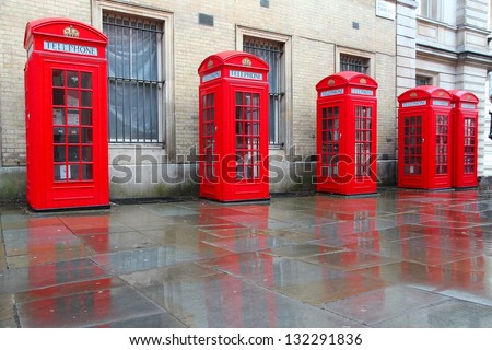 London, United Kingdom - red telephone boxes in wet rainy weather. View of Broad Court, Covent Garden.