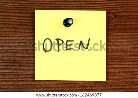 Yellow paper note with message - open. Bulletin board.