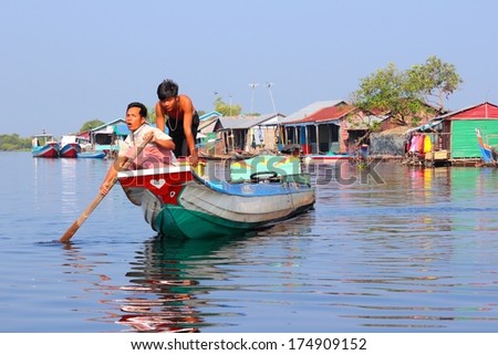 TONLE SAP, CAMBODIA - DECEMBER 11, 2013: Unidentified people ride a boat in floating village on Tonle Sap lake. It is the largest lake in Southeast Asia (up to 16,000 square km).