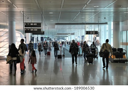MUNICH, GERMANY - APRIL 1, 2014: Travelers walk to gates at Munich International Airport in Germany. It was the 7th busiest airport in Europe with 38,360,604 passengers in 2012.