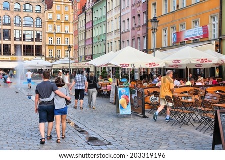 WROCLAW, POLAND - JULY 6, 2014: People visit Rynek (Market Square) in Wroclaw. Wroclaw is the 4th largest city in Poland with 632,067 people (2013).