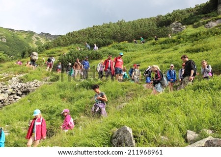 TATRA MOUNTAINS, POLAND - AUGUST 9, 2014: Tourists hike in Tatra Mountains, Poland. Tatra National Park was visited by 2.7 million people in 2013.