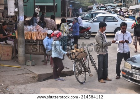 BATTAMBANG, CAMBODIA - DECEMBER 11, 2013: Unidentified people go about their daily life in Battambang. With 180 thousand citizens it is the 2nd most populous town in Cambodia.