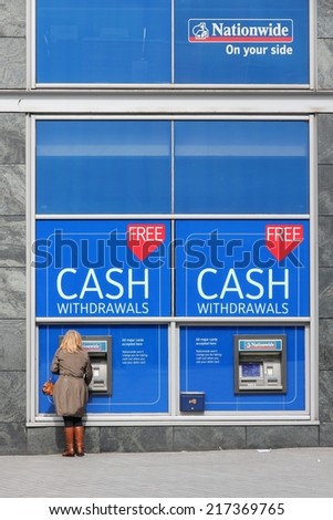 BIRMINGHAM, UK - APRIL 19, 2013: Person withdraws cash in Nationwide ATM in Birmingham, UK. Nationwide Building Society Group has 193.3 billion GBP in assets (2013).