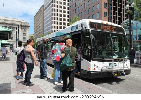 PROVIDENCE, USA - JUNE 8, 2013: People board city bus in Providence, Rhode Island. Providence is the capital and most populous city (178,000 people) of Rhode Island.