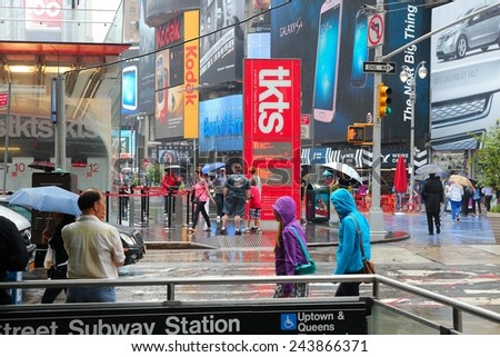 NEW YORK, USA - JUNE 10, 2013: People walk in rain in Times Square, NY. Times Square is one of most recognized places in the world. More than 300,000 people pass through Times Square daily.