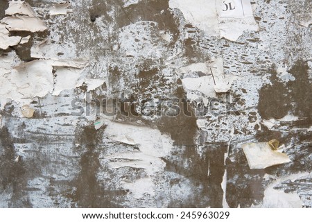 Old paper posters and advertisements torn off an urban wall. Background abstract.