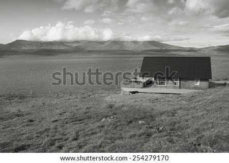 Generic village home next to Hvalfjordur fiord in Iceland. Black and white monochrome tone.