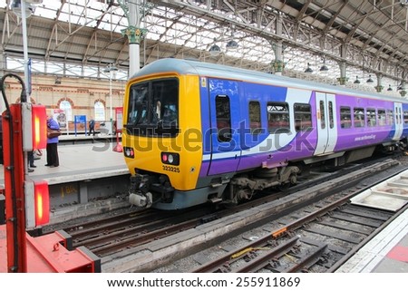 MANCHESTER, UK - APRIL 23, 2013: People walk by Northern Rail train in Manchester, UK. NR is part of Serco-Abellio joint venture. NR has fleet of 313 trains and calls at 529 stations.