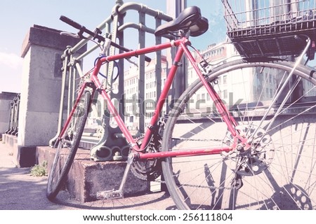 Red bicycle parked in the city (Vienna, Austria) - red bike. Vintage color style - cross processed filtered colors tone.