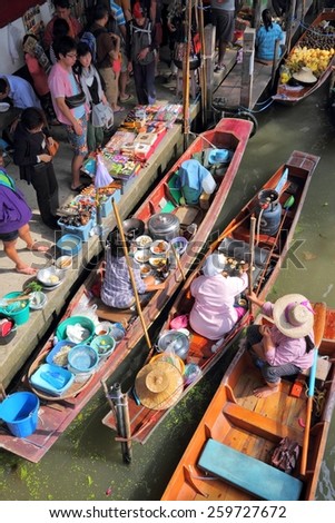 RATCHABURI, THAILAND - DECEMBER 24, 2013: People visit Damnoen Saduak floating market. Damnoen Saduak is the most popular floating market in Thailand.