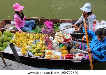 RATCHABURI, THAILAND - DECEMBER 24, 2013: Vendors sell food at Damnoen Saduak floating market. Damnoen Saduak is the most popular floating market in Thailand.