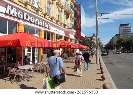 SOFIA, BULGARIA - AUGUST 17, 2012: People walk by McDonald\'s restaurant in Sofia, Bulgaria. McDonald\'s is the 2nd most successful restaurant franchise in the world with 33,000 locations.