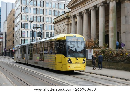 MANCHESTER, UK - APRIL 21, 2013: People ride Manchester tram in Manchester, UK. Manchester Metrolink serves 21 million rides annually (2011).