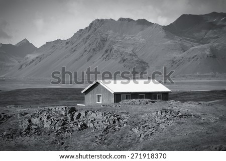 Landscape in Lonsoraefi region in Iceland. Small wooden home. Black and white toned image.