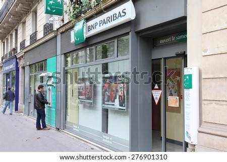 PARIS, FRANCE - JULY 23, 2011: Person visits BNP Paribas Bank branch in Paris, France. Formed through merger in 2000, the bank is currently largest worldwide by assets ($2.68 trillion USD).