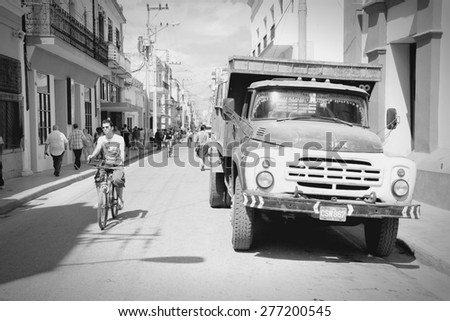 CAMAGUEY, CUBA - FEBRUARY 17, 2011: People walk by a classic Soviet Zil truck parked in Camaguey, Cuba. Cuba has one of the lowest car-per-capita rates (38 per 1000 people in 2008).