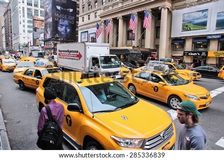 NEW YORK, USA - JULY 1, 2013: People ride yellow taxis in 7th Avenue, New York. As of 2012 there were 13,237 yellow taxi cabs registered in New York City.
