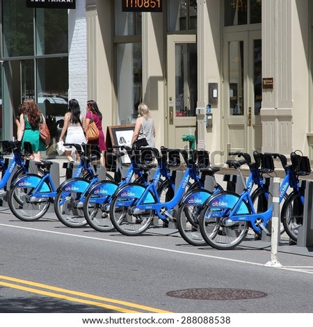 NEW YORK, USA - JULY 2, 2013: People walk past Citibike bicycle sharing station in New York. With 330 stations and 6,000 bicycles it is one of top 10 bike sharing systems in the world.