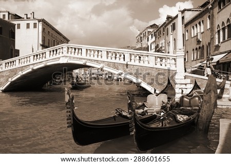 Venice, Italy - gondolas. Old bridge and Mediterranean architecture. Sepia tone - retro monochrome color style.