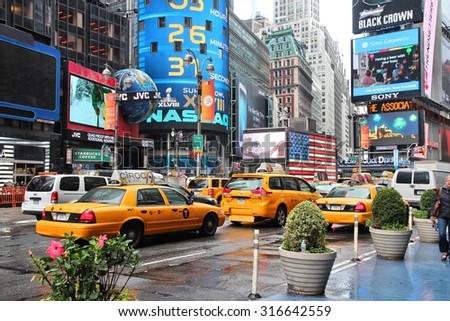 NEW YORK, USA - JUNE 10, 2013: Taxis drive in rainy Times Square, NY. Times Square is one of most recognized places in the world. More than 300,000 people pass through Times Square daily.