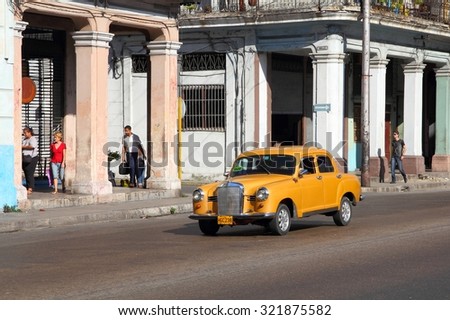 HAVANA, CUBA - FEBRUARY 24, 2011: People drive old car in Havana. Cuba has one of the lowest car-per-capita rates (38 per 1000 people in 2008).