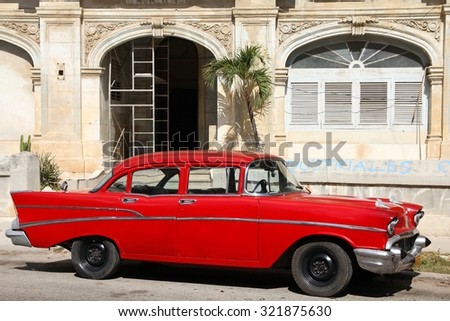 HAVANA, CUBA - FEBRUARY 24, 2011: Classic red car in Havana. Cuba has one of the lowest car-per-capita rates (38 per 1000 people in 2008).