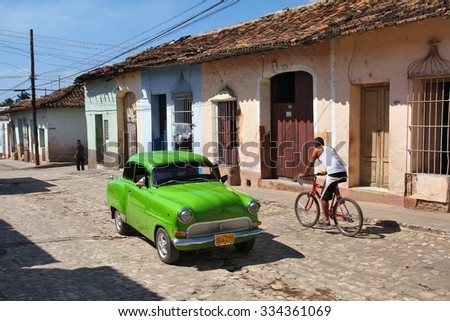 TRINIDAD, CUBA - FEBRUARY 5, 2011: People drive an oldtimer car in Trinidad. Cuba has one of the lowest car-per-capita rates (38 per 1000 people in 2008).