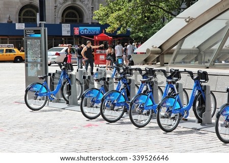 NEW YORK, USA - JULY 4, 2013: People walk past Citibike bicycle sharing station in New York. WIth 330 stations and 6,000 bicycles it is one of top 10 bike sharing systems in the world.