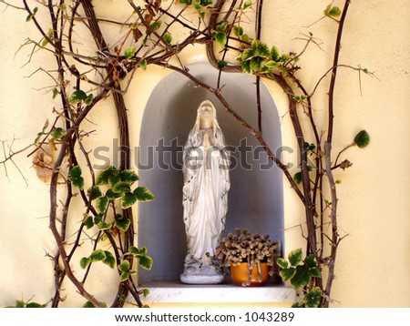 White little sculpture of holy mother mary in an alcove