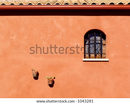 Orange wall with a window and two bizarre flower pots