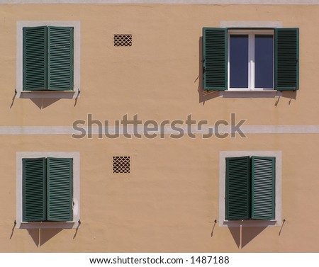 Four windows, one closed. Nice windows with green shutters. Orange wall.
