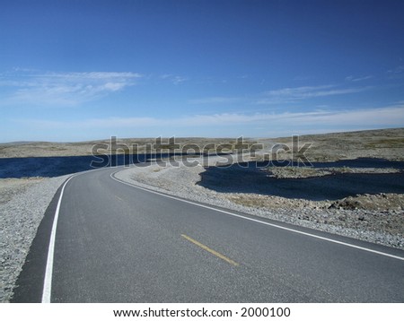Norwegian plains landscape. A road among lakes in a stone desert.