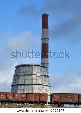 Industrial factory and cargo train. Chimney and a cooling tower.