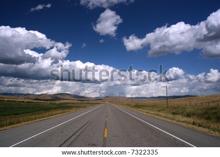 Straight, endless road in Canadian prairie. Landscape of Alberta province in Canada.