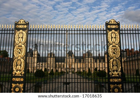 Decorative gate with golden ornaments - entrance to Fontainebleau castle in France. Chateau is inscribed to UNESCO world heritage list.