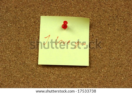 Yellow small sticky note on an office cork bulletin board. I love you confession.