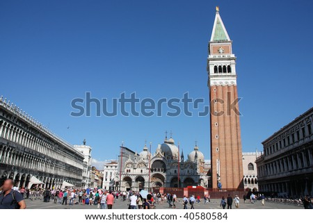 Famous Saint Mark\'s Square in Venice with Basilica San Marco and its iconic campanile tower. Recognizable faces have been blurred.
